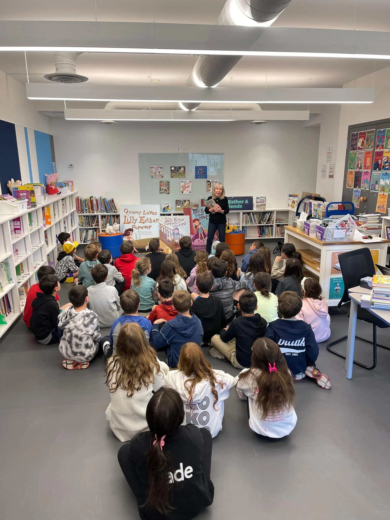 Phyllis reading to a large class in a school library
